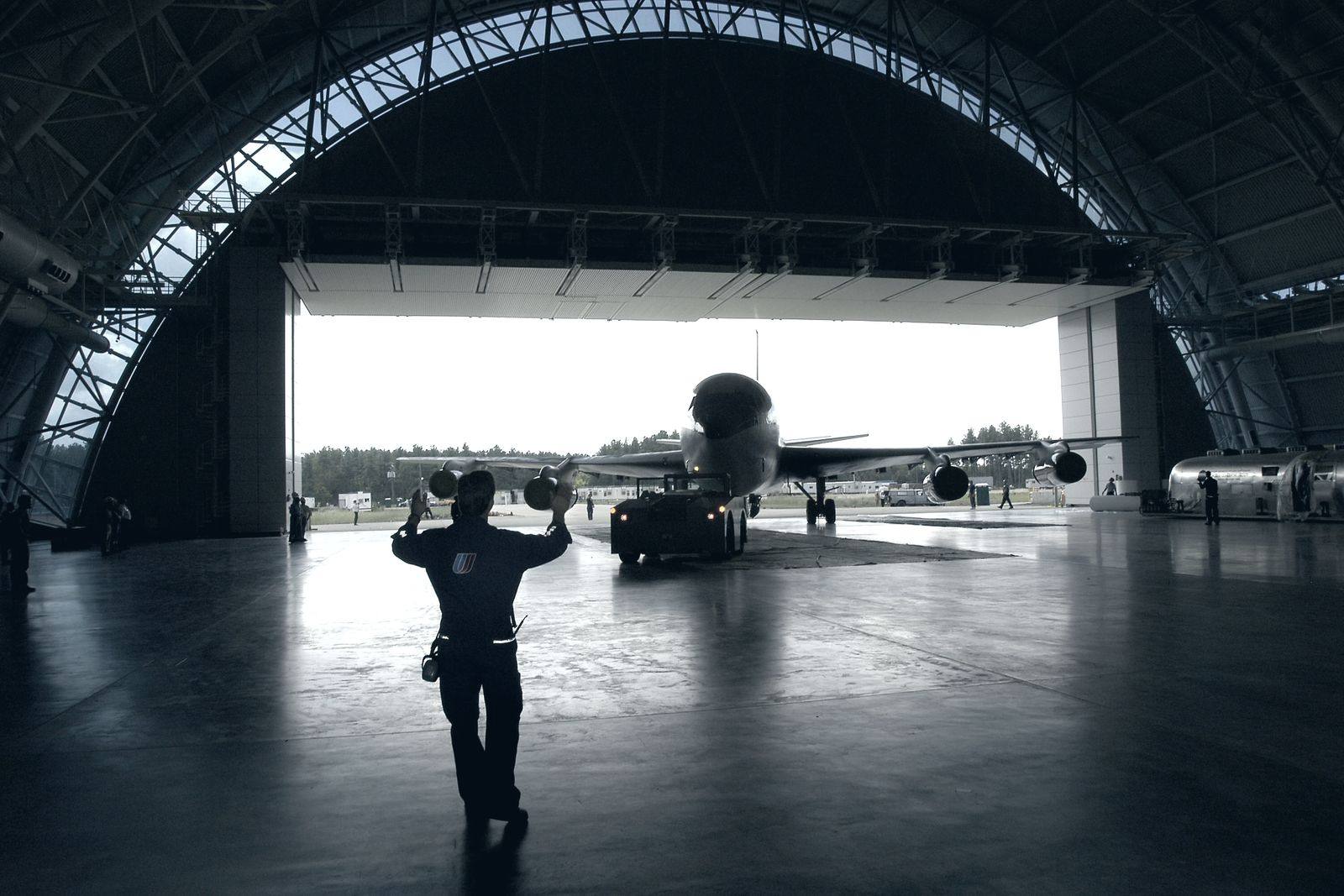 Aircraft being marshalled inside a maintenance hangar