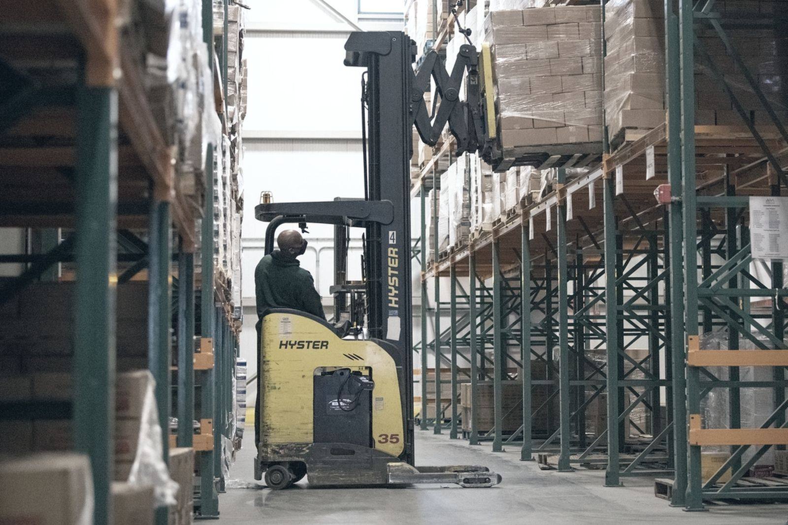 Industrial warehouse racking with a forklift working an aisle